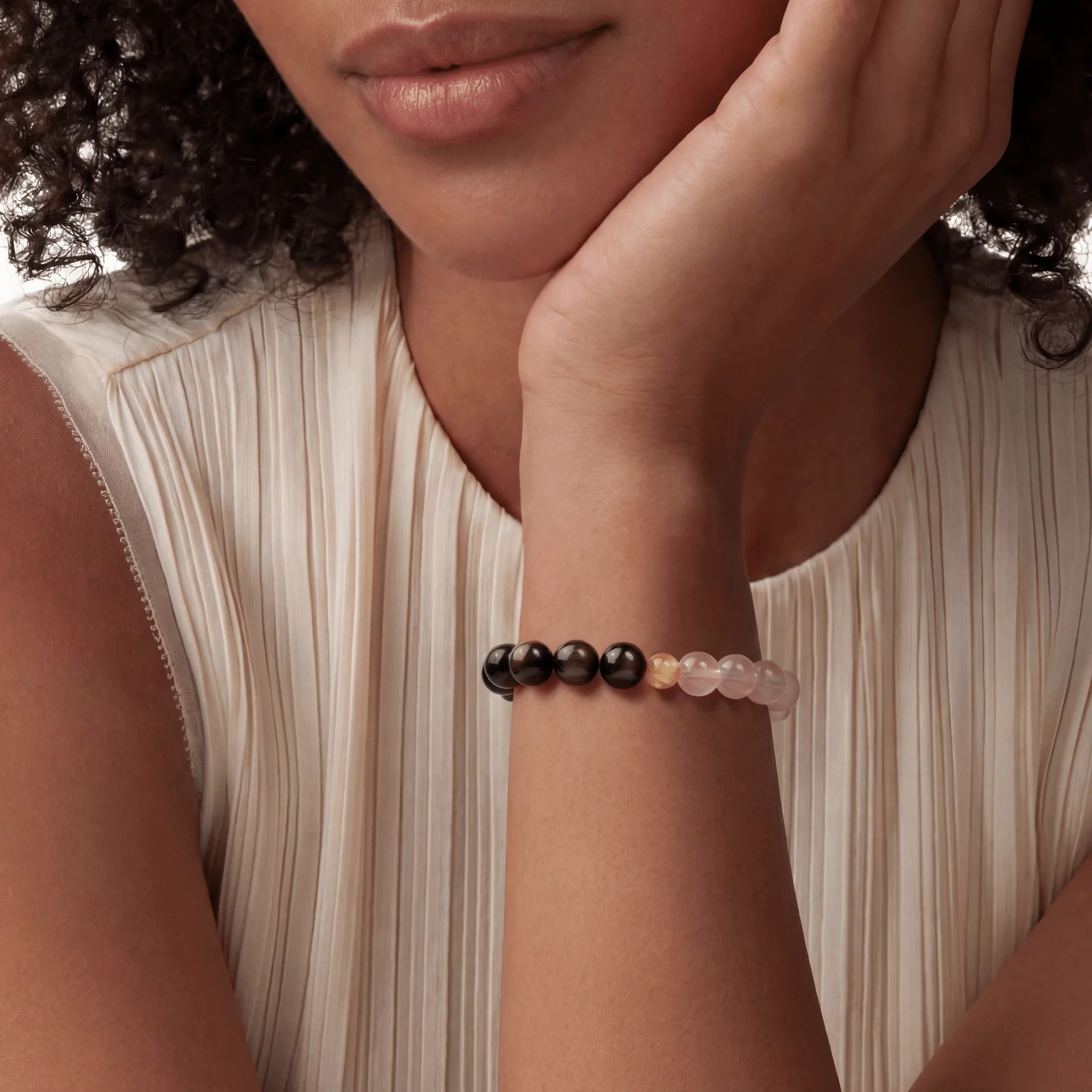 The Dual-Mineral Strand — Obsidian & Quartz, bracelet worn on wrist, lifestyle model photo BE.