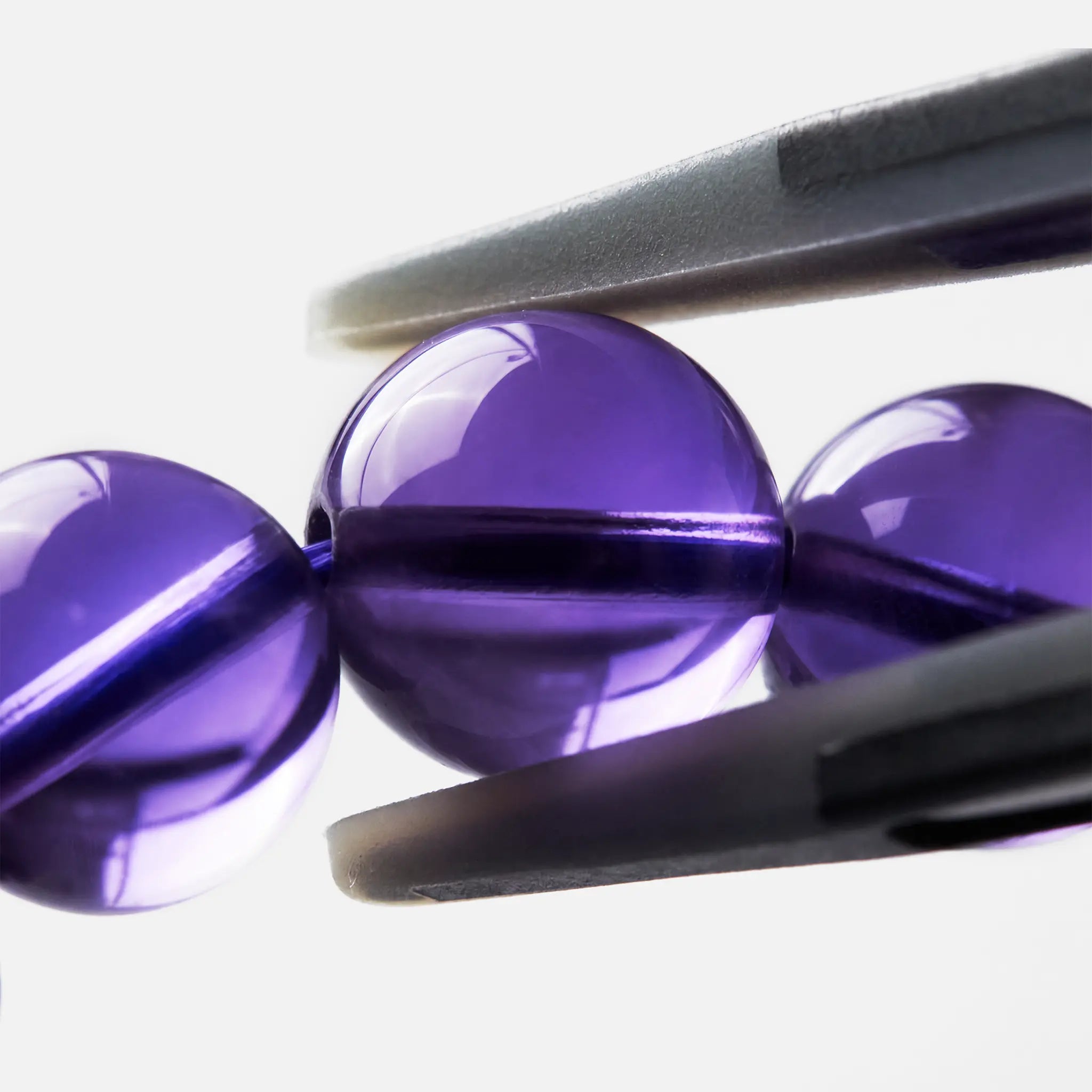 Bolivian Amethyst Triple-Strand close-up — deep violet colour zoning, BE.