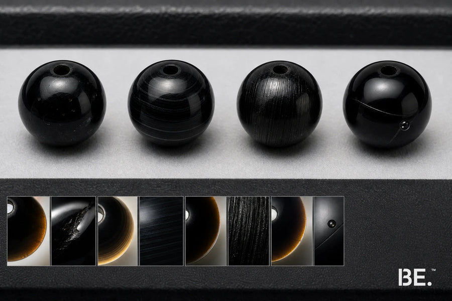 Four black beads comparing obsidian, onyx, tourmaline and manufactured glass clues — BE.
