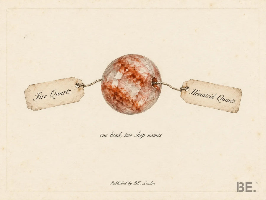 One hematoid quartz bead with red iron inclusions, tied to two paper shop tags reading Fire Quartz and Hematoid Quartz