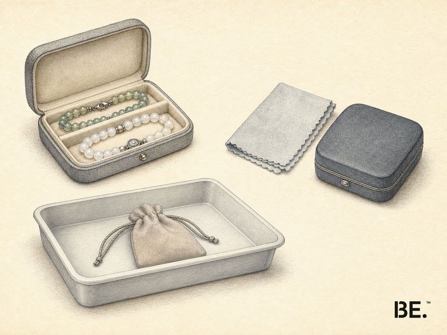 Illustrative travel-preparation plate showing two bead bracelets secured in an open jewellery case beside a polishing cloth, closed zipped case, security tray and drawstring pouch