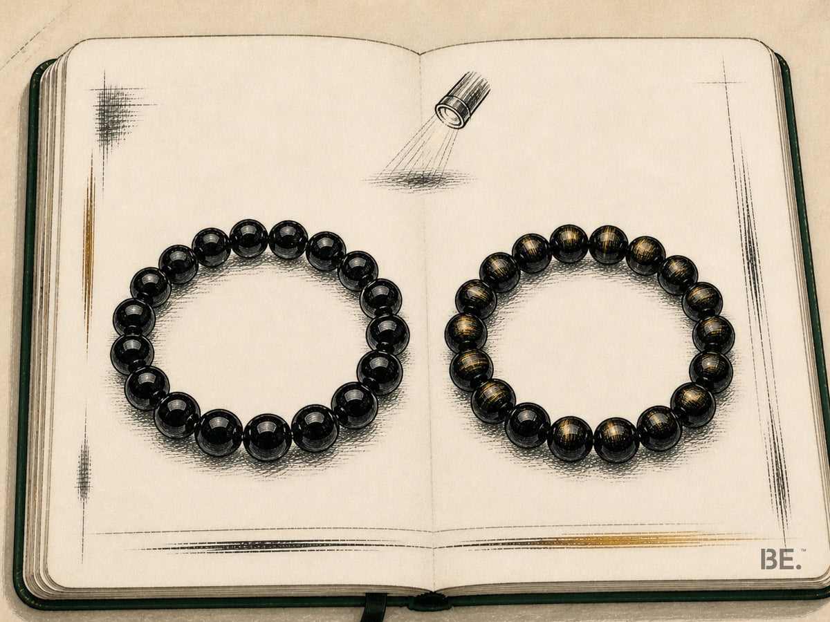 Field-notebook comparison of plain black obsidian and gold sheen obsidian bracelets beneath a directional lamp