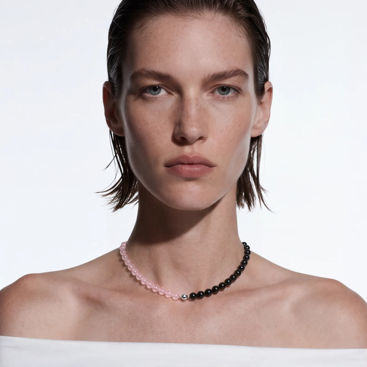 Choker: a pink and a black strand joined at the front, worn at the base of the neck