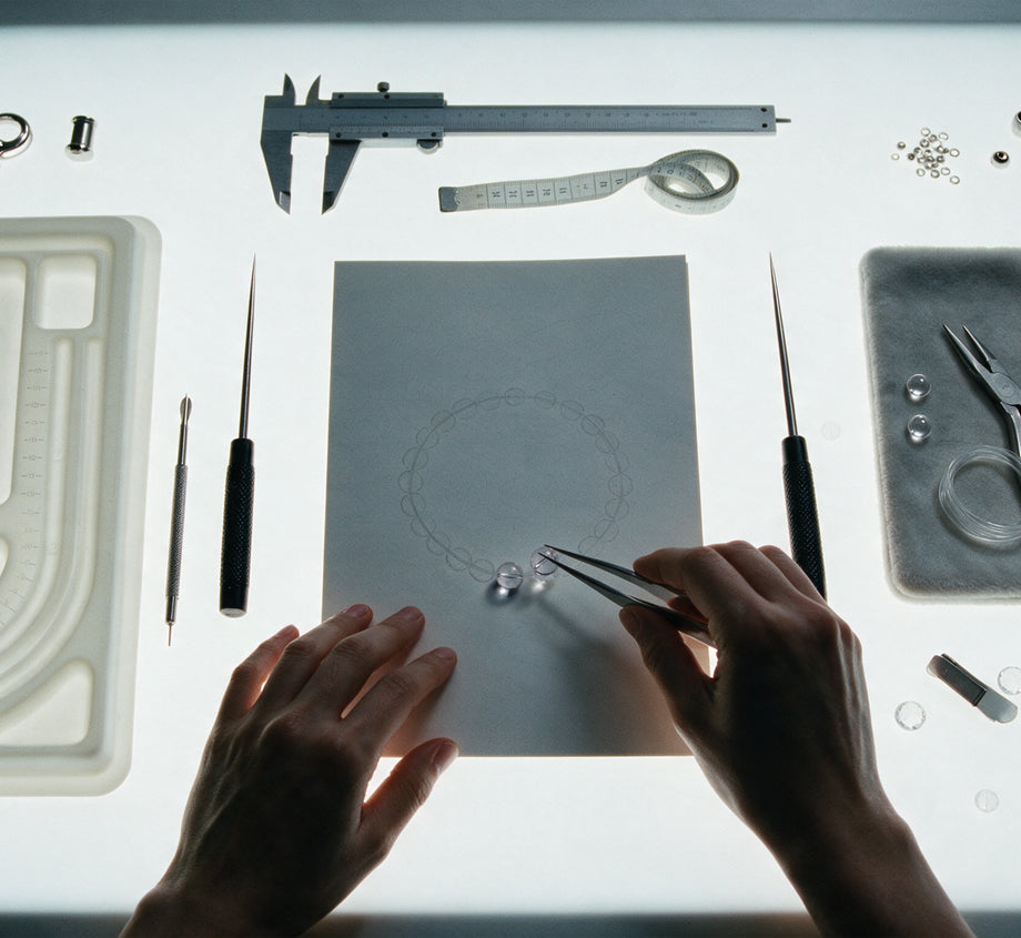 Hands assembling a clear quartz bracelet