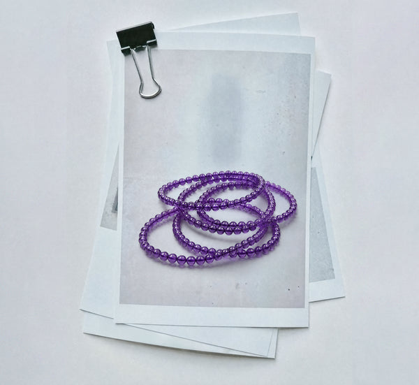 Amethyst bracelets arranged on translucent paper in the studio