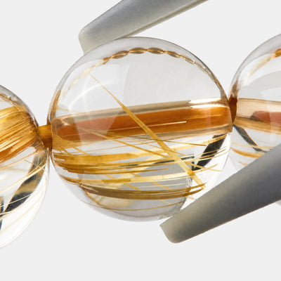 Golden Rutilated Quartz Bracelet close-up — fine golden rutile threads in clear quartz, angled view, BE.