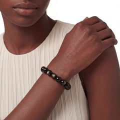 The Obsidian Strand — Gold Sheen, bracelet worn on wrist, lifestyle model photo BE.