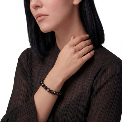 The Obsidian Strand — Gold Sheen, bracelet on wrist, lifestyle model photo BE.
