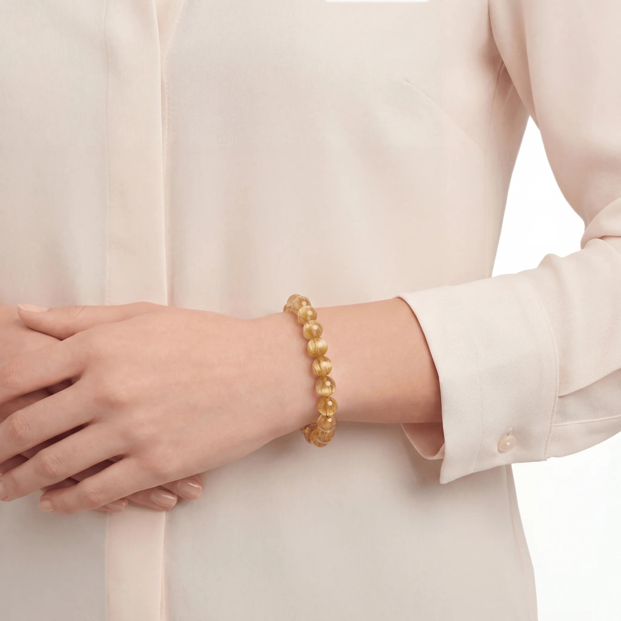 The Rutilated Quartz Strand — Golden Array, bracelet on wrist, lifestyle model photo BE.