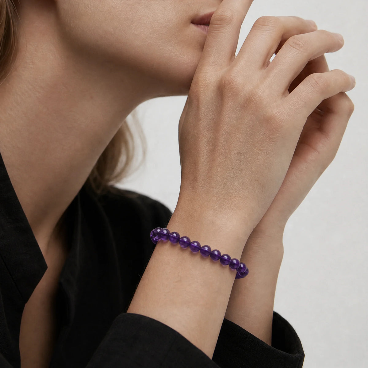 The 6mm Bolivian Amethyst Strand Bracelet - Bolivian Depth worn at the wrist, BE.
