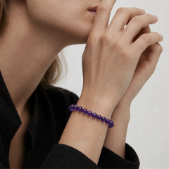 The 6mm Bolivian Amethyst Strand Bracelet - Bolivian Depth worn at the wrist, BE.