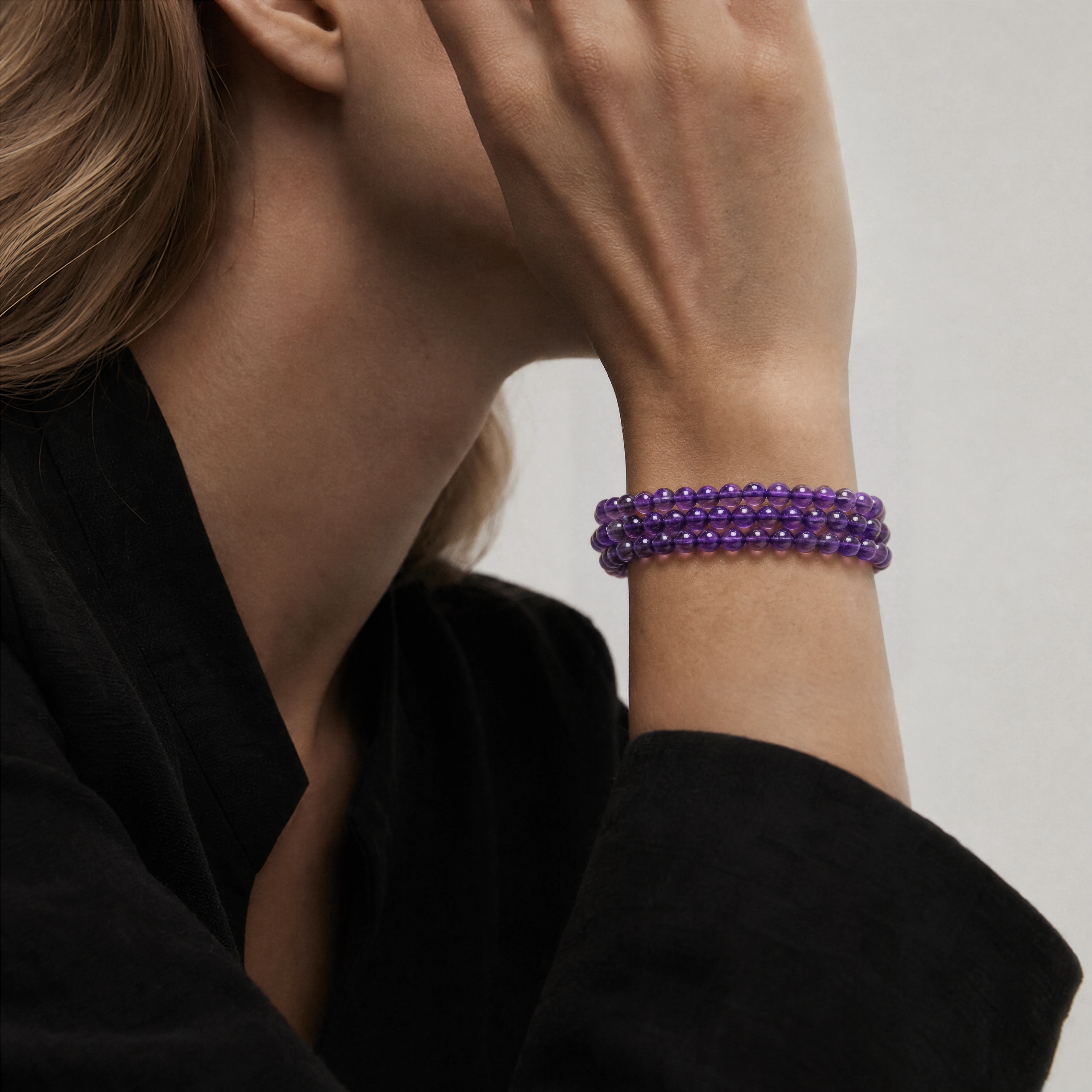 The Bolivian Amethyst Triple-Strand Bracelet Necklace worn layered at the wrist, BE.