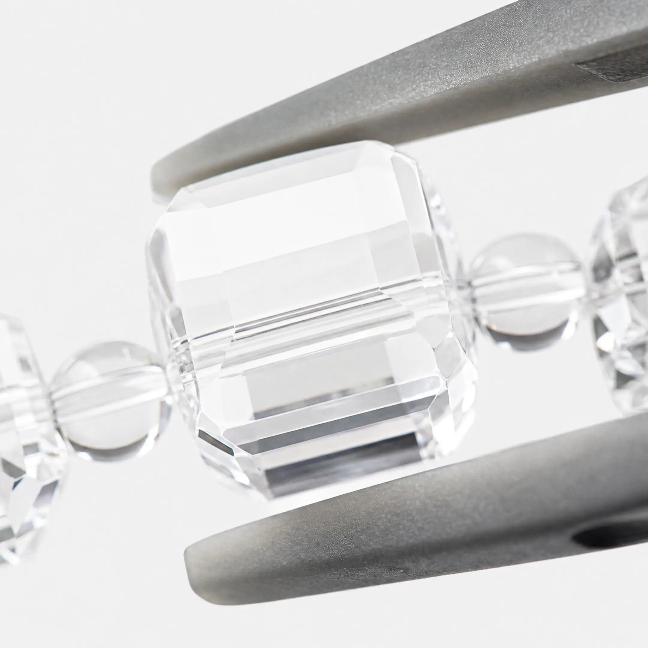 Clear Quartz Bracelet close-up — faceted clear quartz cube geometry, angled view, BE.