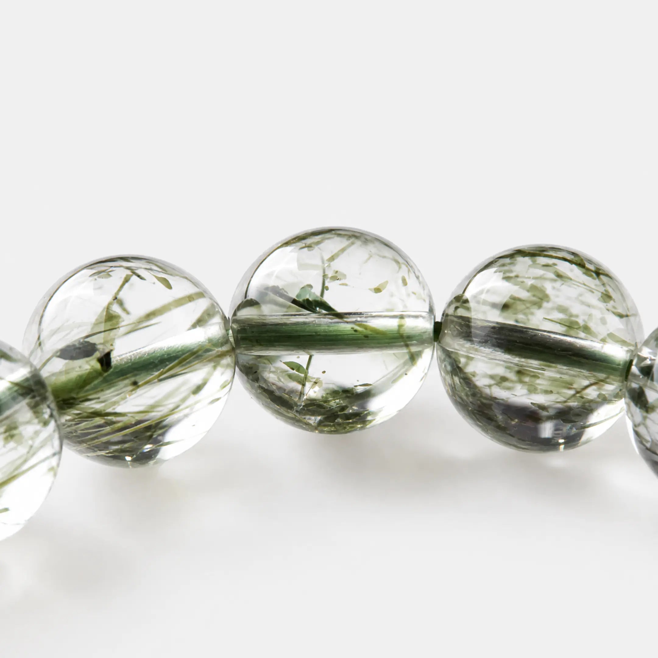 Green Rutilated Quartz Bracelet close-up — fine green mineral needles suspended in clear quartz, BE.