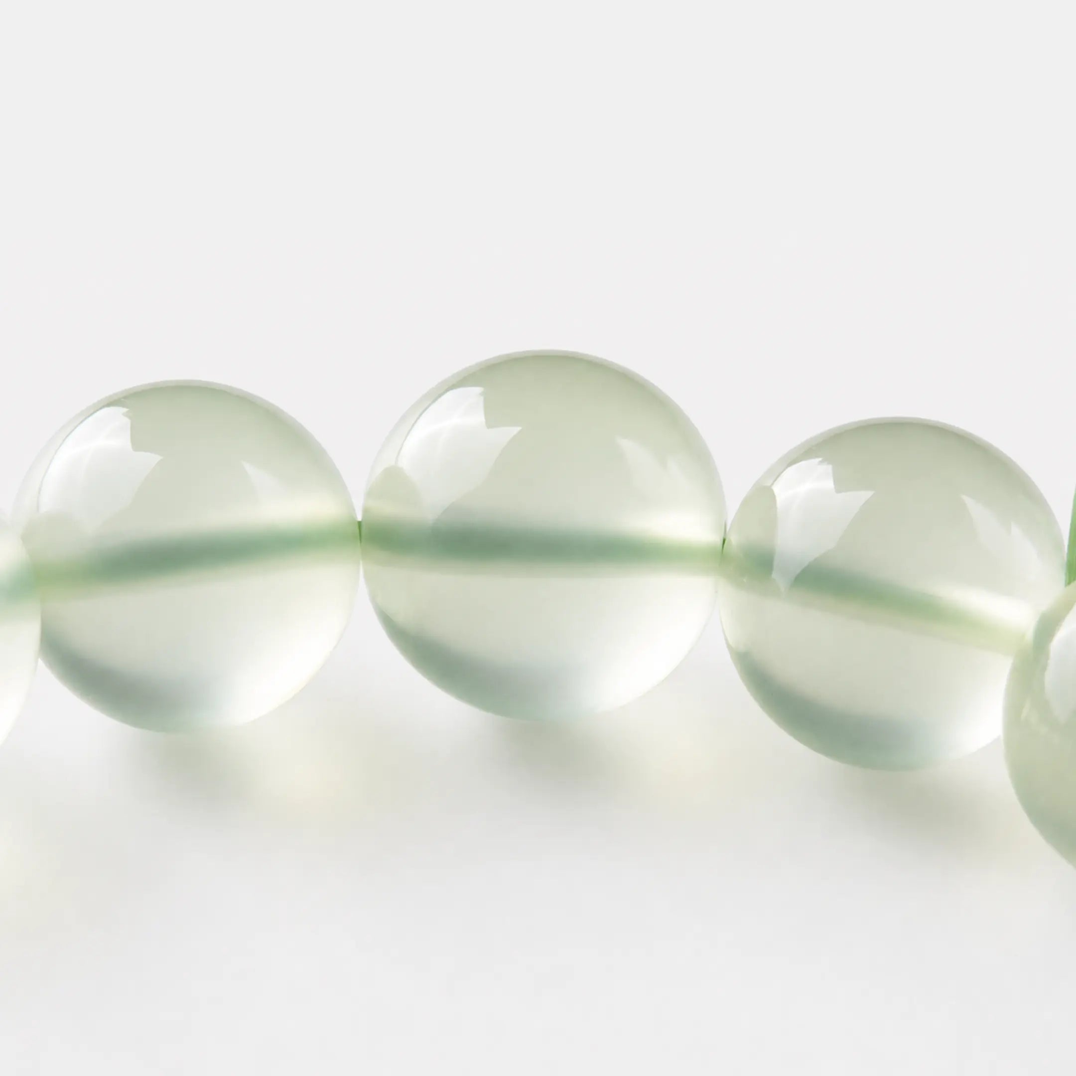 Prehnite Bracelet close-up — translucent green prehnite with dark epidote inclusions, BE.