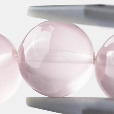 Rose Quartz Bracelet close-up — soft pink tone and translucent quartz surface, angled view, BE.